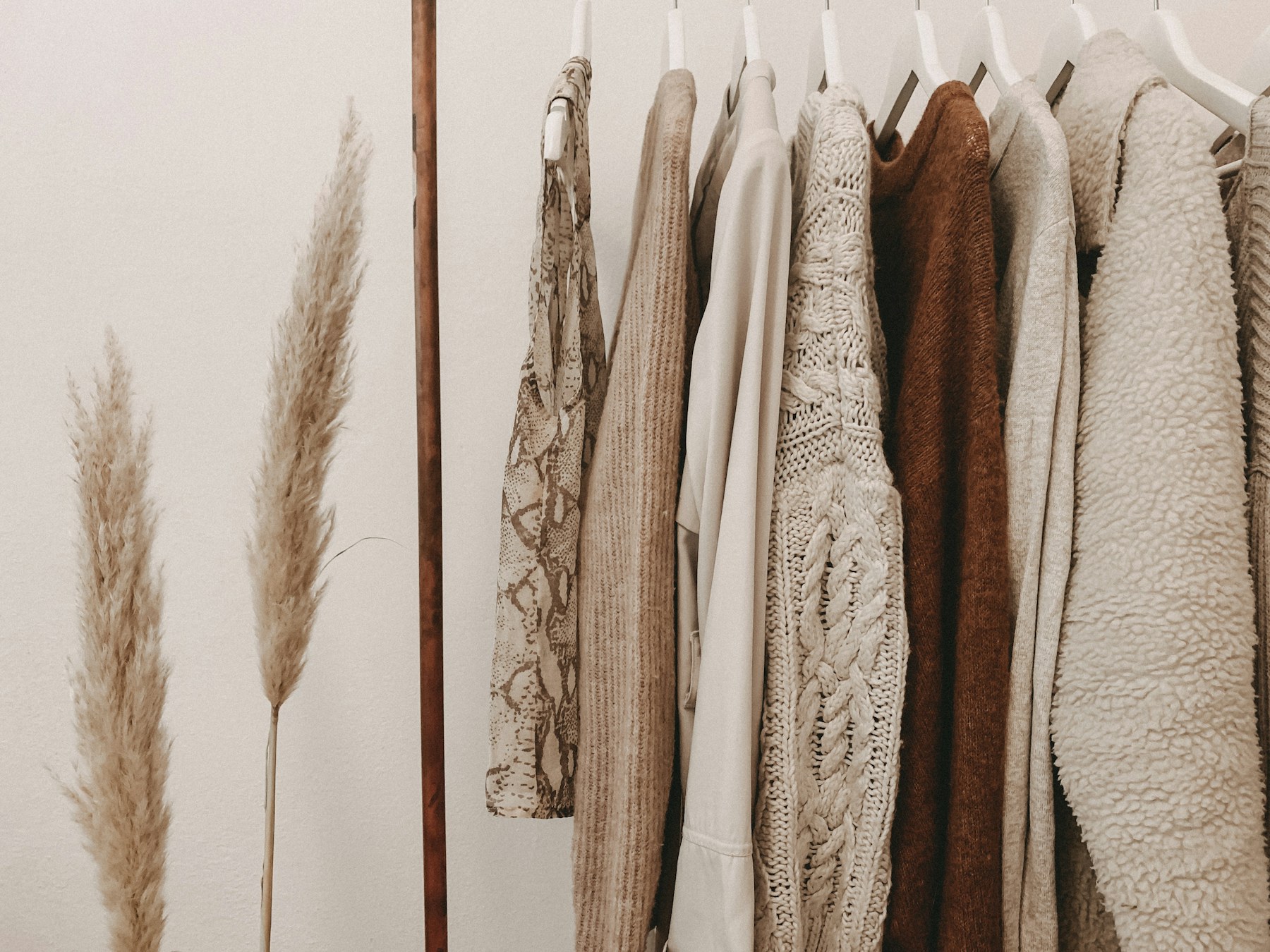 Roupas femininas claras organizadas em cabides